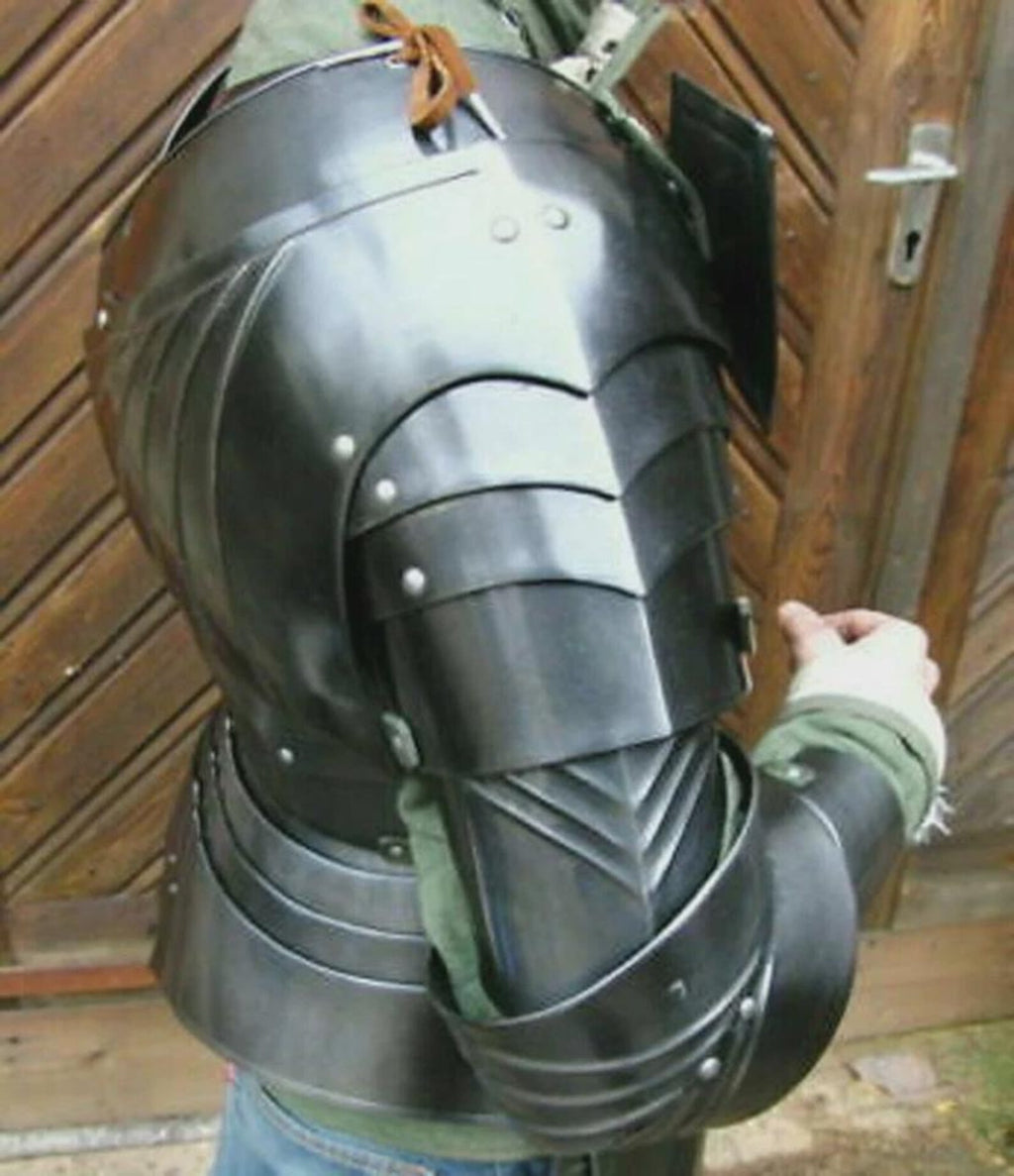 Person wearing a black medieval steel armor suit with chest plate, shoulder guards, and arm protection.
