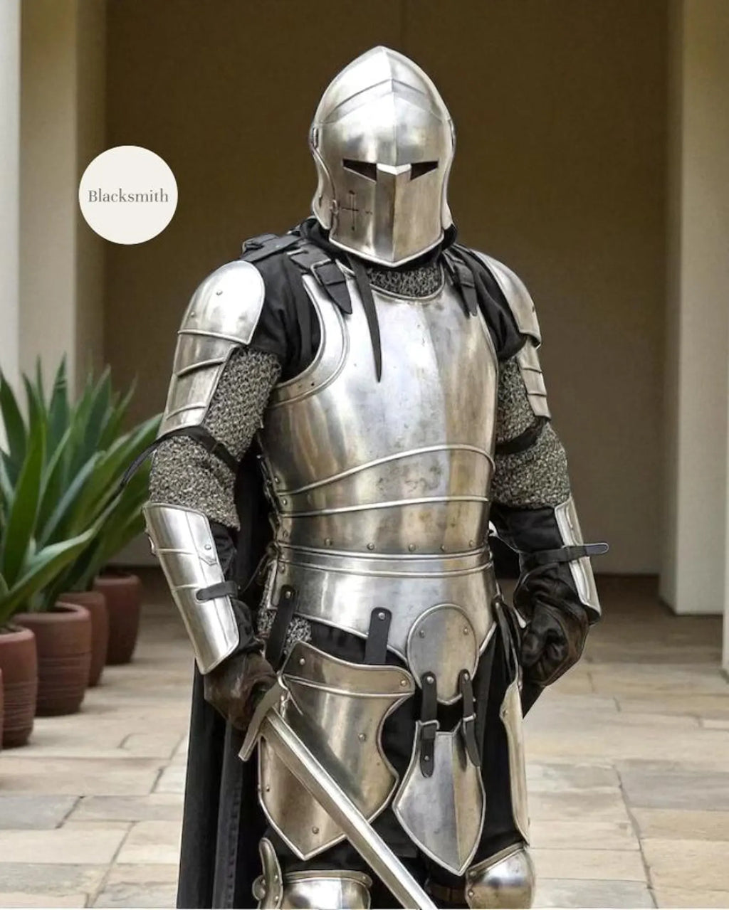 Person wearing a full medieval steel knight armor suit with helmet, holding a sword.