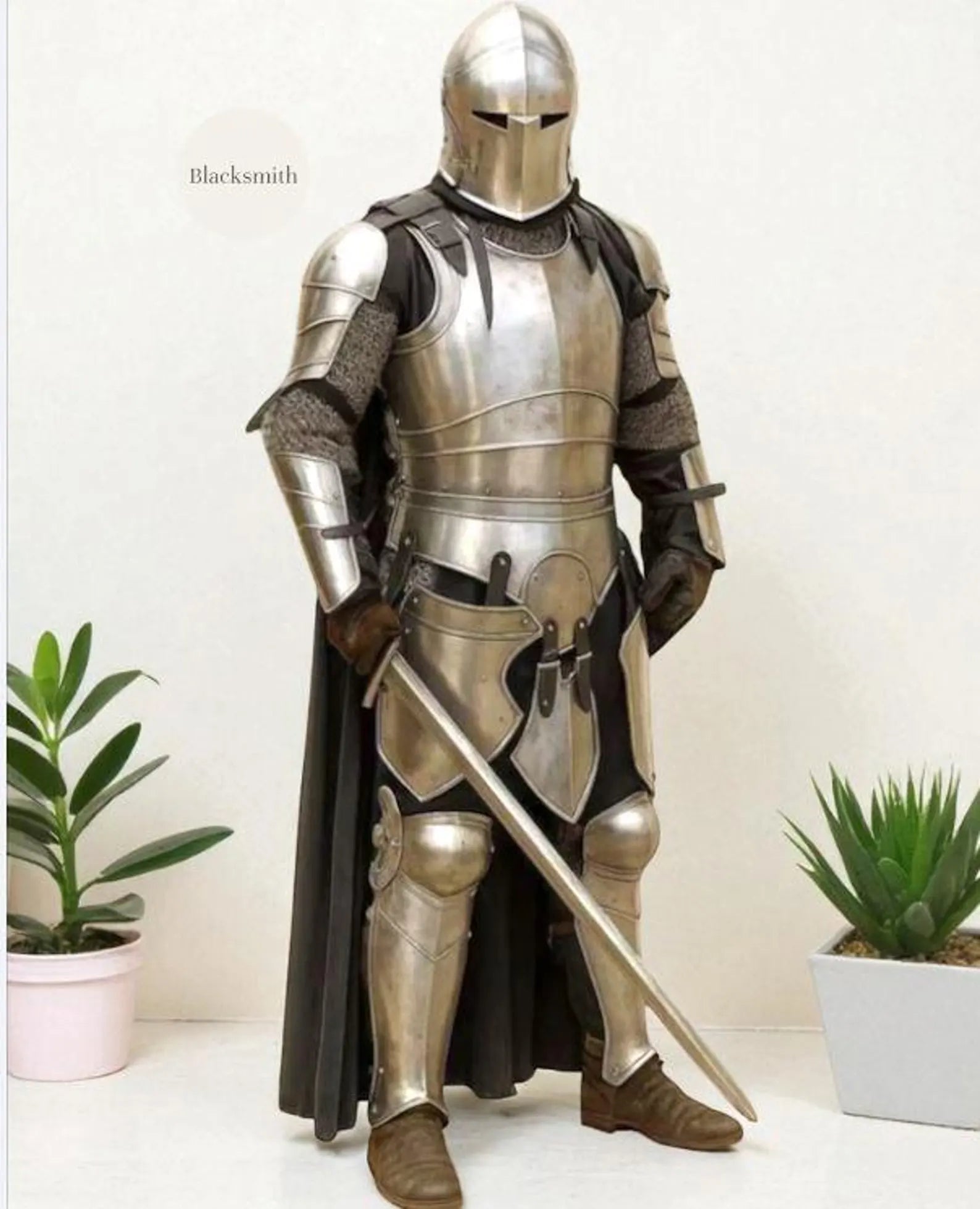 Person wearing a full medieval steel knight armor suit with helmet, holding a sword.