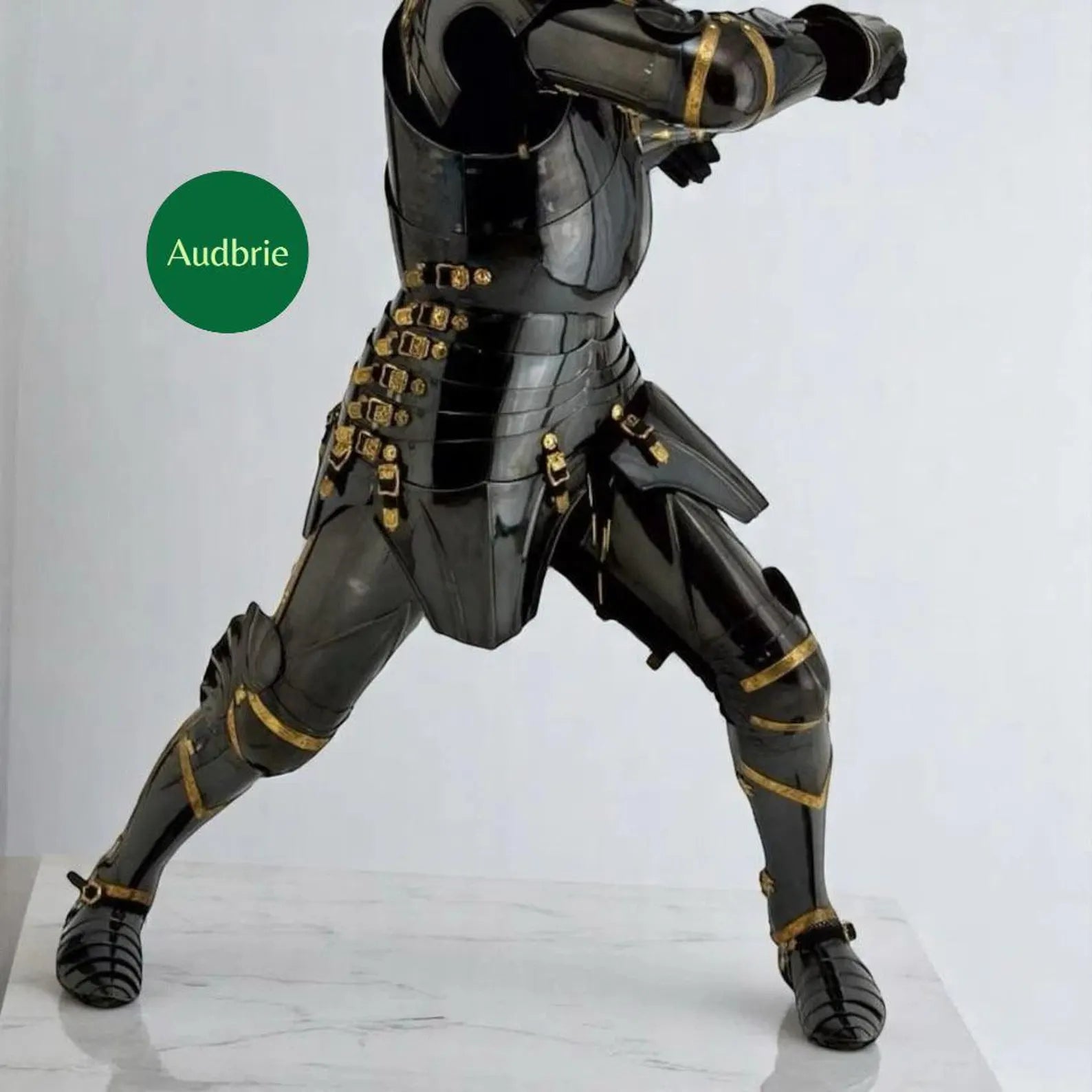 Black and gold armored figure on a white background with 'Audbrie' branding.