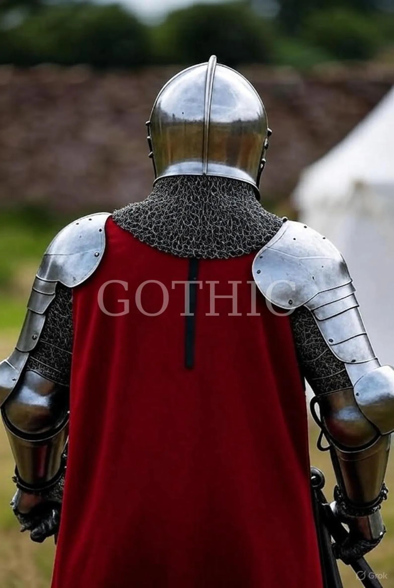 Person wearing medieval armor with a red cape, standing outdoors.