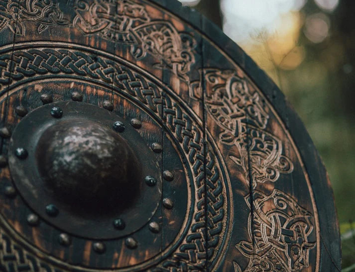 Wooden round Viking shield featuring intricate Norse dragon carving